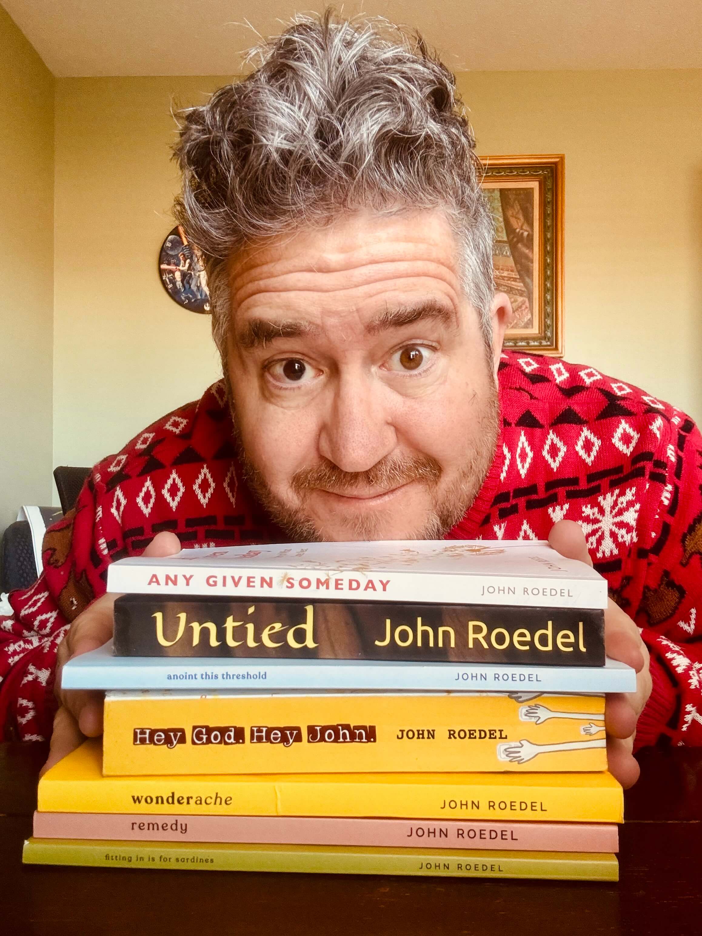 John Roedel pictured in front of his published books.