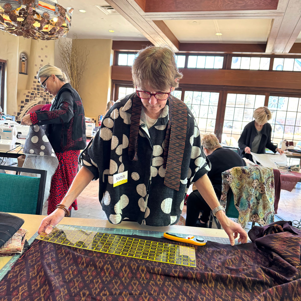 Woman measuring fabric in a sewing workshop.
