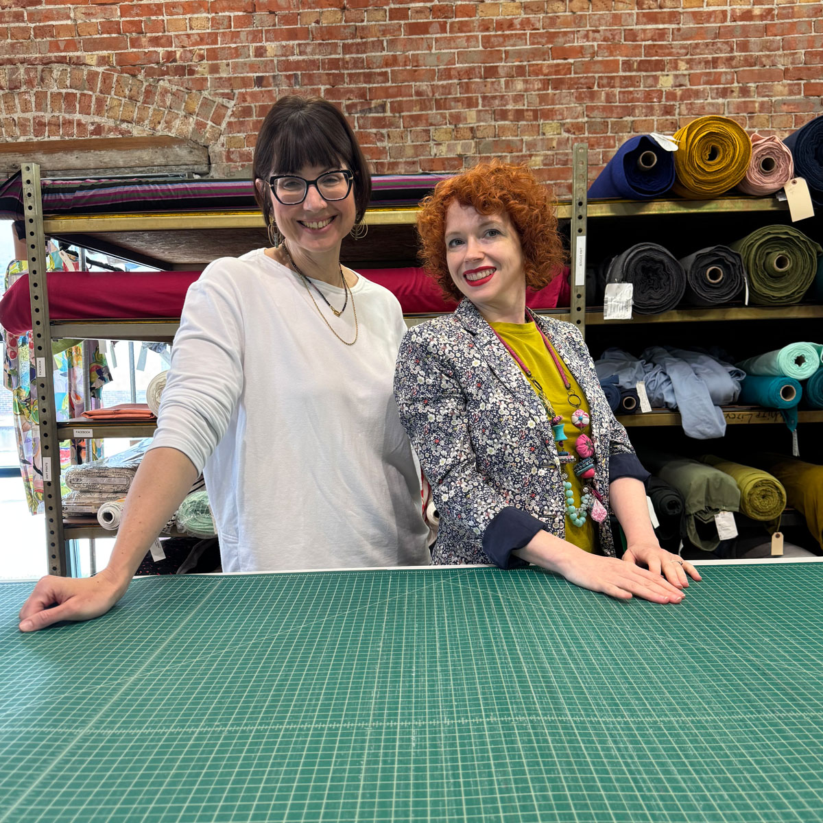Sewing workshop tutors at cutting table.