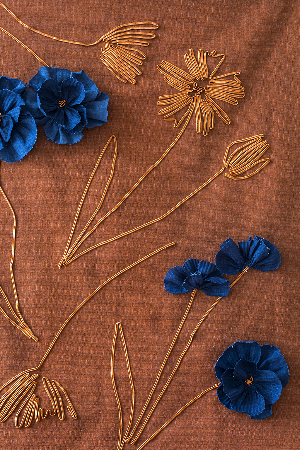 Embroidery on orange background with blue flowers.