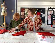 Two women at cutting table.