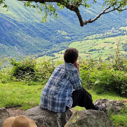 Woman sitting and looking at the view of Pyrénées Mountains.