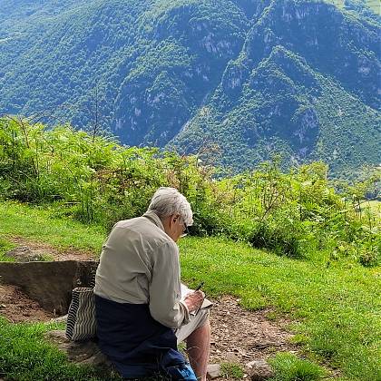 Man writing in the mountains - creative retreat.