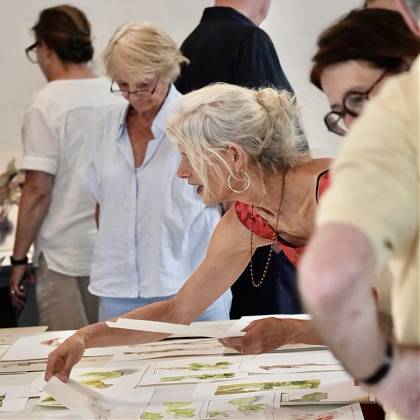 Wendy Artin looking at group artwork.