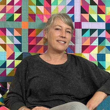 Quilting workshop tutor Tara Faughnan sitting in front of her quilt design.