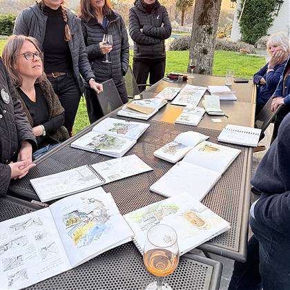 Group reviewing sketch books with tutor Rita Sabler.