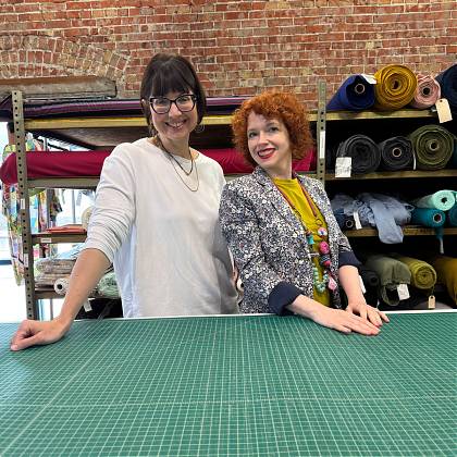 Sewing workshop tutors at cutting table.