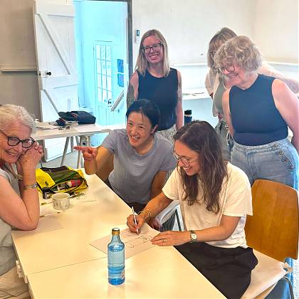 Six ladies smiling and watching live sketching demo with Samantha Dion Baker.