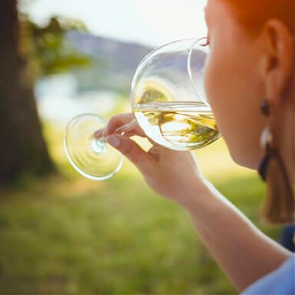 Woman drinking a glass of Jurançon wine in garden of Clos Mirabel.
