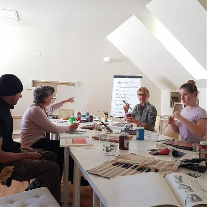 Four participants sitting at a table in Clos Mirabel art studio.
