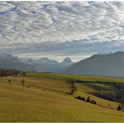 Meadows, cloudy sky, mountain range.